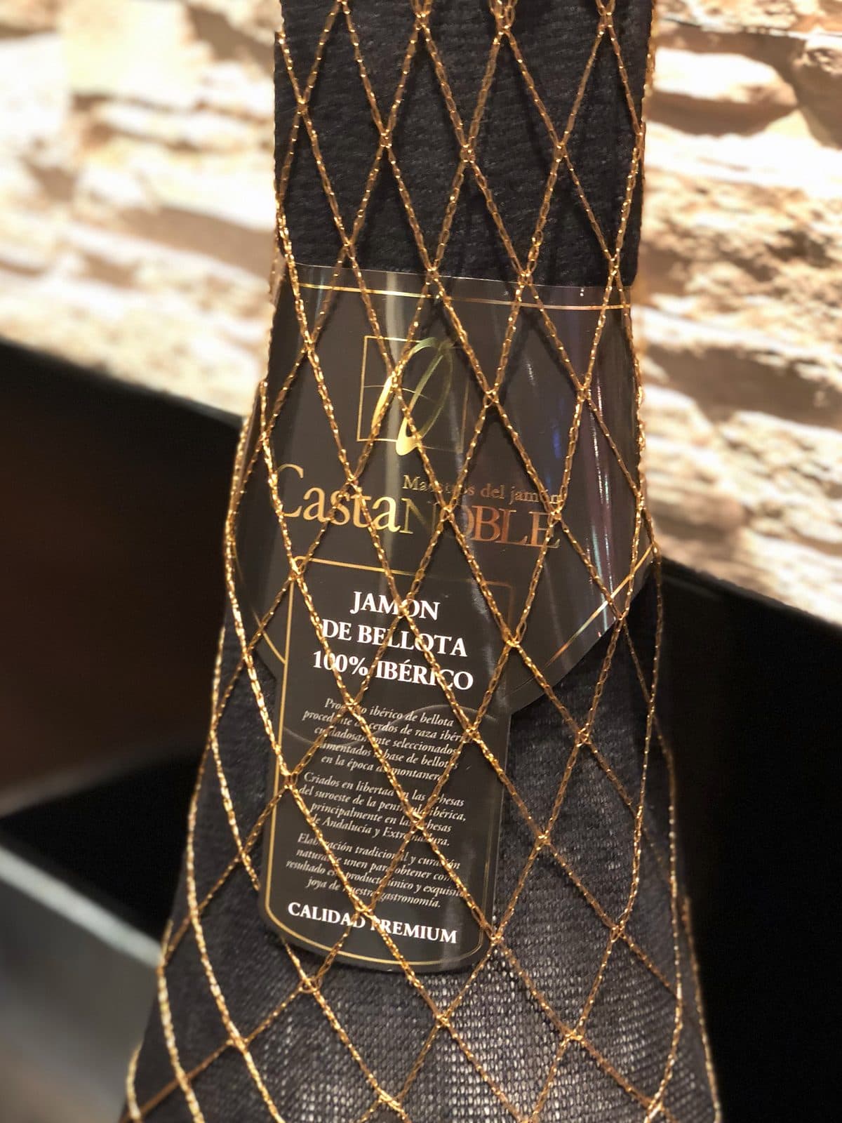 Jamón de bellota 100 % ibérico Castanoble con su malla y su etiqueta