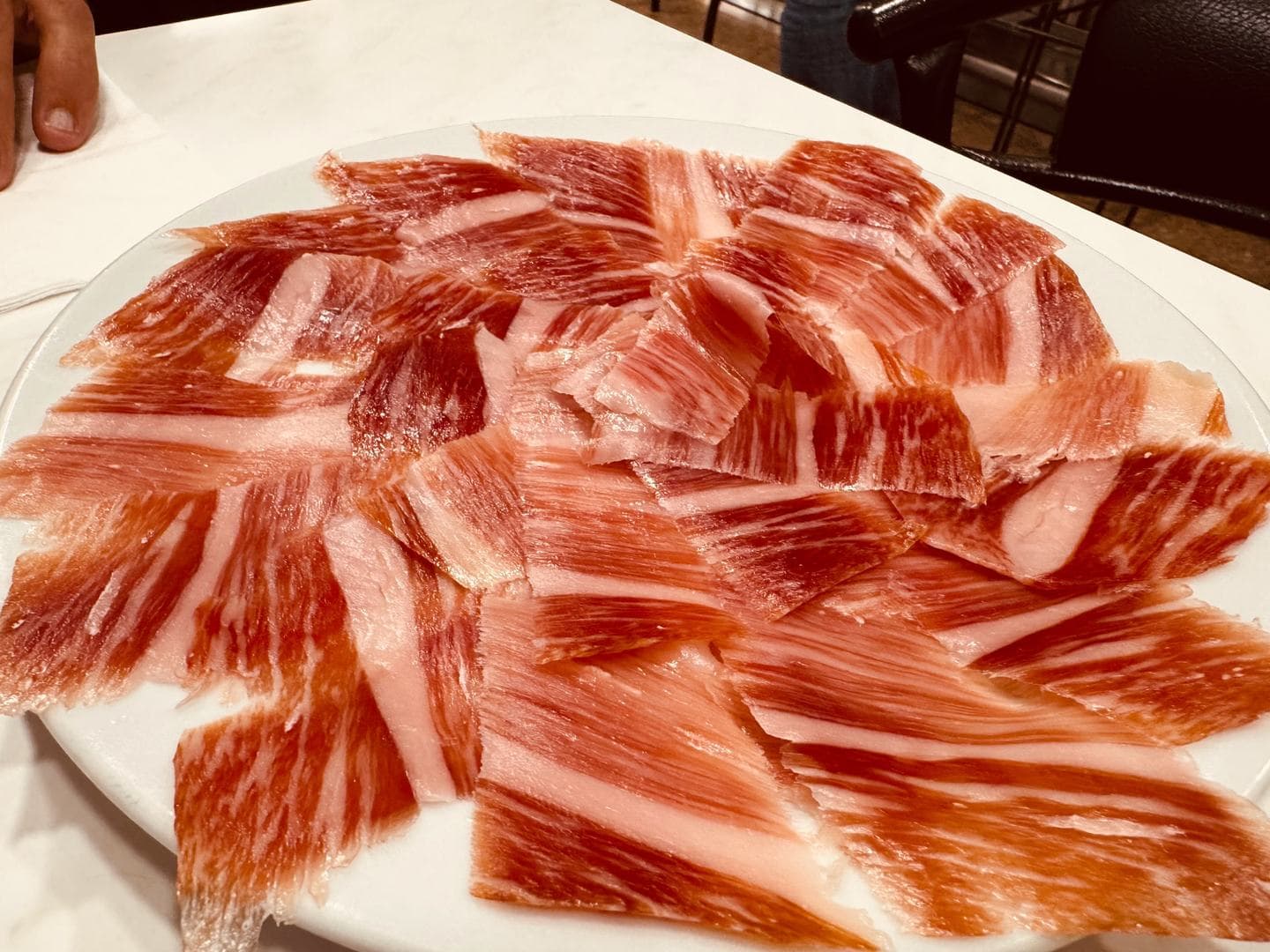 Plato de jamón ibérico loncheado, con la grasa infiltrada entre el magro.