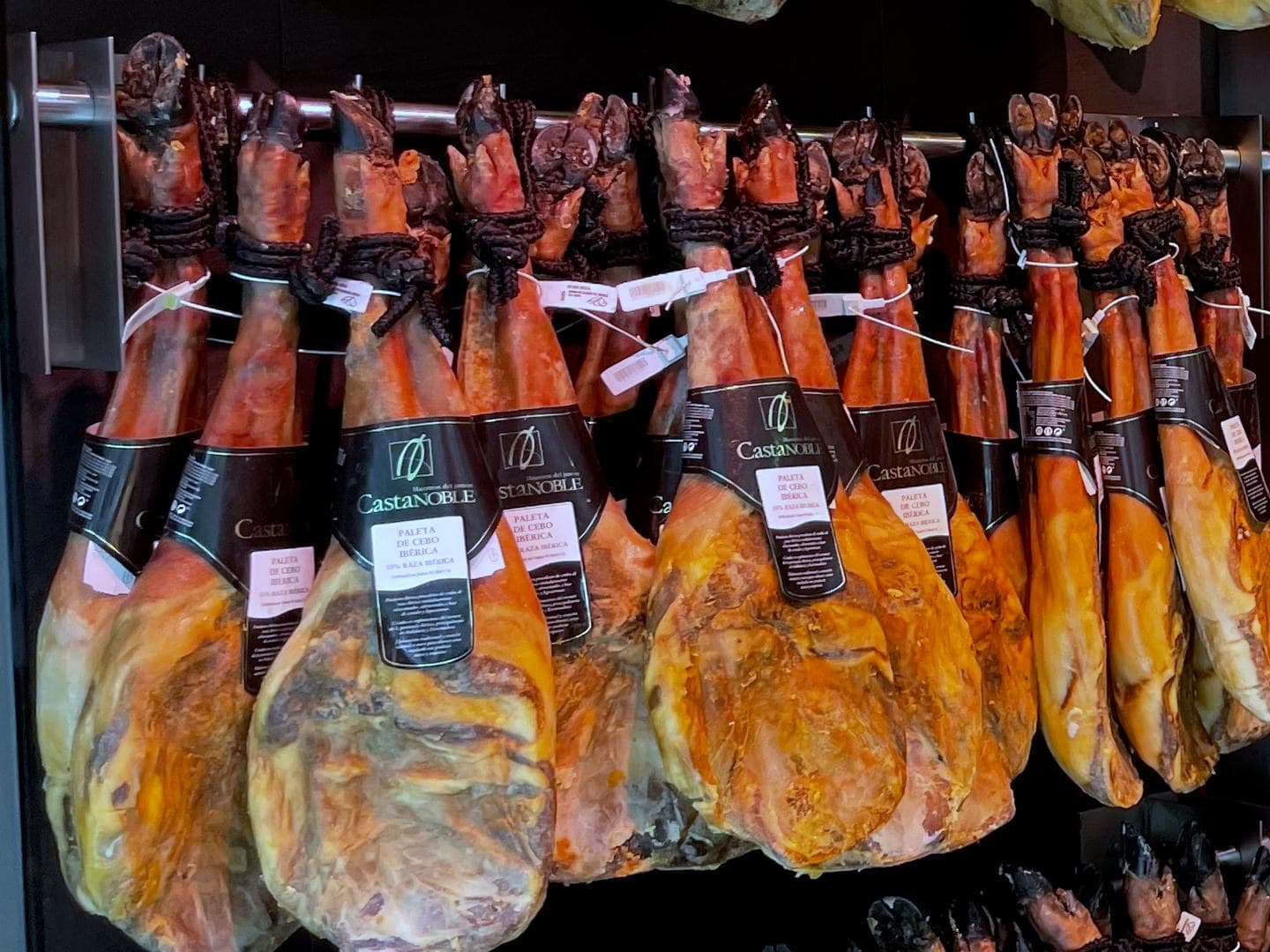 Paletas de cebo ibéricas colgadas en nuestra tienda de Barcelona, con su etiqueta.