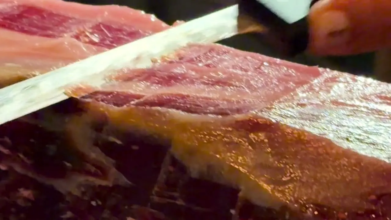 Cuchillo jamonero sacando una loncha de jamón